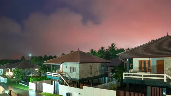 Glow of clouds at night against the houses in the tropics on Koh Phangan, Thailand