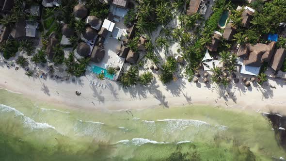 Aerial cenital drone shot of tropical beach with exclusive tourist resort