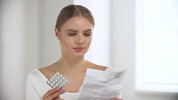 Medicament. Woman Reading Pills Instruction At Light Interior