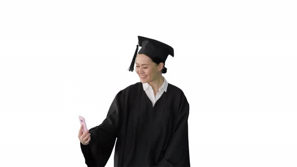 Happy Female Graduate in Mortarboard Making Selfie on Her Phone on White Background.