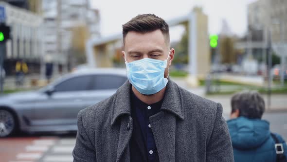 Handsome man wearing a protective mask, walking in the city. 