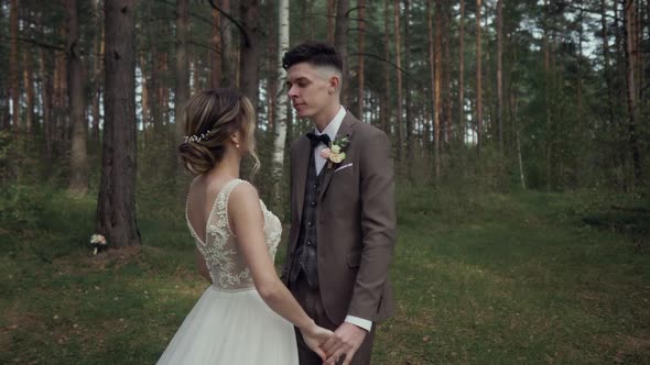 Beautiful Young Wedding Couple in Beautiful Forest. Hugs, Kisses and Smiles