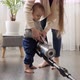 Mother doing housework teaching and giving vacuum cleaner to her baby - VideoHive Item for Sale