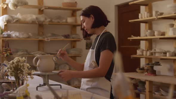 Young female potter working in her studio