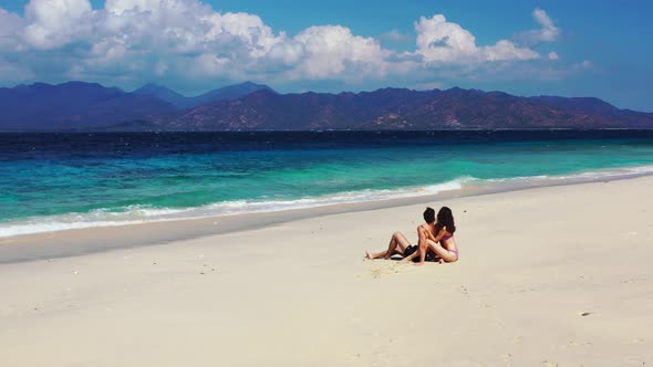 Happy lady and man in love dating on vacation have fun on beach on white sand 4K background