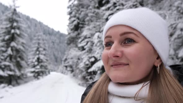 A Lonely Girl Walks on a Snowy Road in the Middle of Christmas Trees