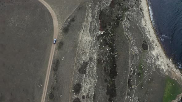 Offroad Car Drives Along Ground Road Running on Rocky Cliffs