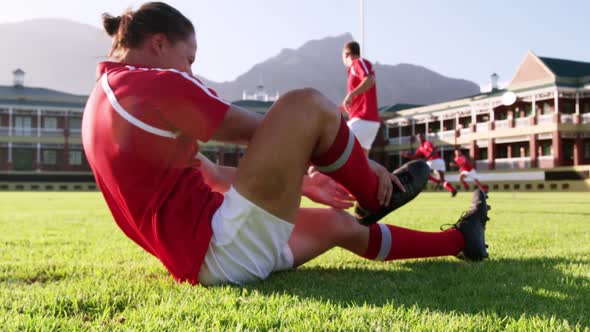 Male rugby player sitting on the ground in stadium 4k