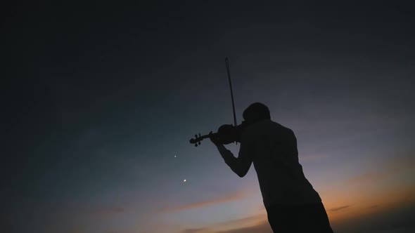 Silhouette of Young Man Figure in the Sunrays Playing the Violin Boy Relaxing and Moving Bow Along