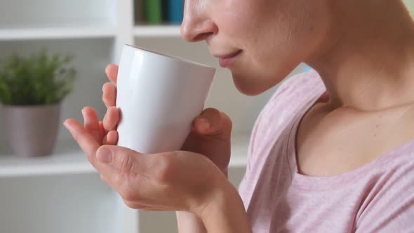 Charming Caucasian Woman with Cup of Tea on Bed