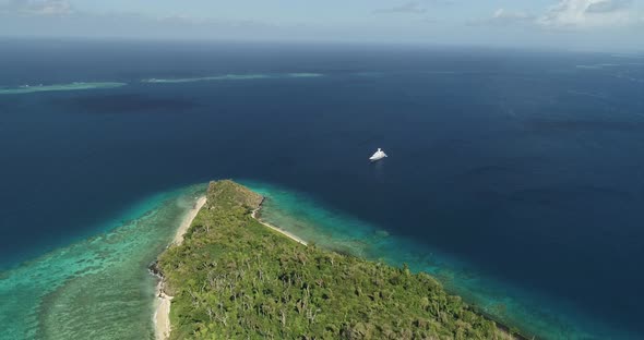 Aerial footage of ocean and land on an island in Tonga. Wide angle, vast ocean view