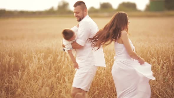 Mother and Father Lifting Their Son High Into the Air