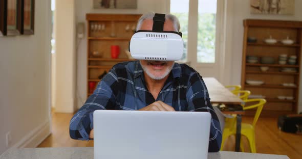 Senior man using virtual reality headset in kitchen 4k