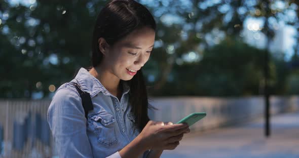 Woman concentrate on using mobile phone at night 