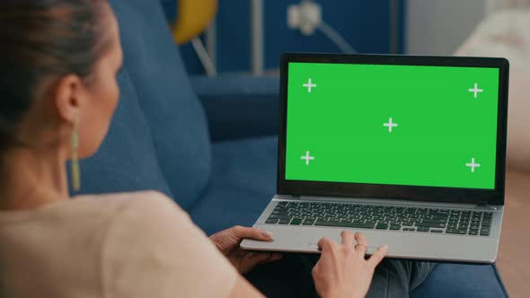 Woman Sitting on Couch in Cozy Living Room Working on Laptop Computer