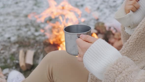 Woman Holding Roasted Marshmallow and a Metal Cup of Tea