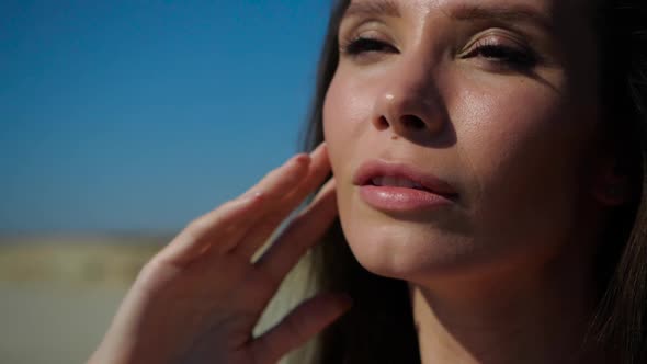 A Tanned Pretty Girl Puts Her Face To the Sun. Close-up