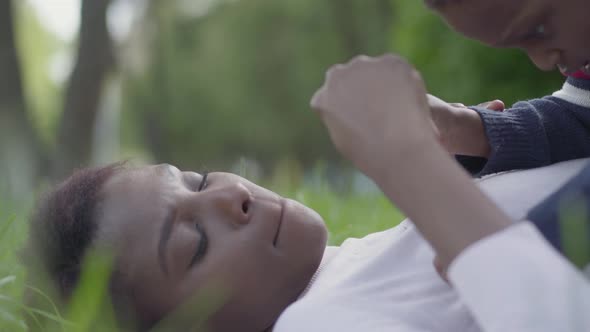 Pretty African American Woman Lying on the Grass in the Park