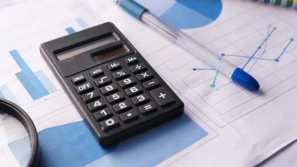 Financial Graph, Calculator and Notepad on Table 