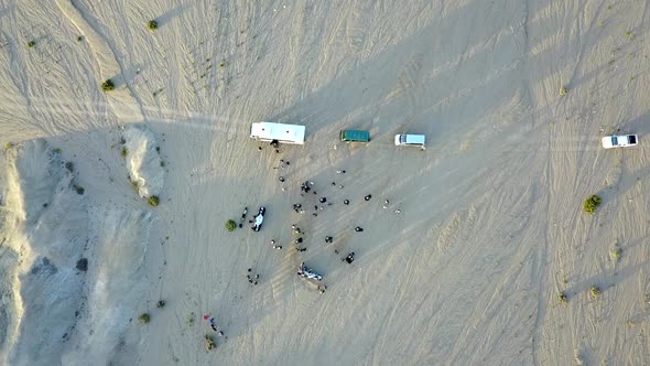 overhead spiral shot of buses and people in the Namibian desert