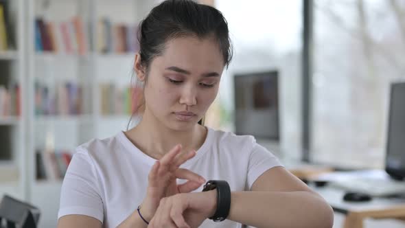 Portrait of Focused Asian Woman Using Smart Watch 