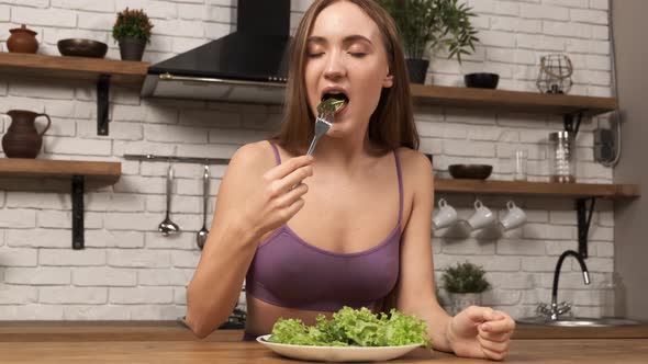 Attractive Sporty Woman Eating a Salad at Home Kitchen