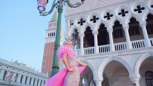 Girl with Pink Dress Moves in the Square in Venice in Front of San Marco Tower