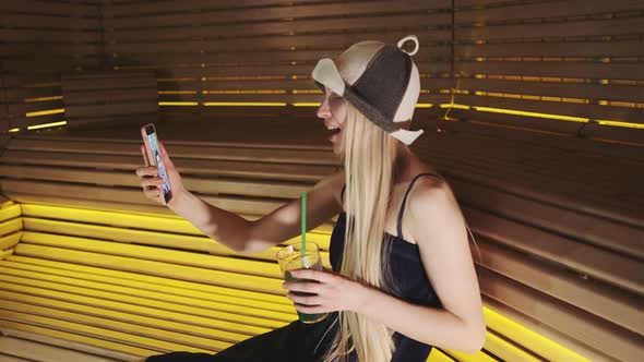 Medium Shot of Woman in Sauna Speaking with Friend By Video Call