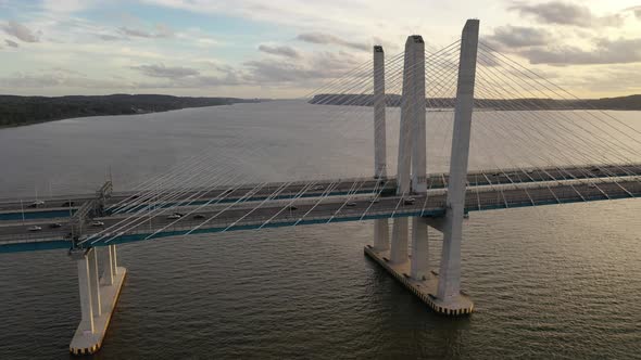 An aerial shot of the side view of the Mario M. Cuomo Bridge, taken on the north side. The camera tr