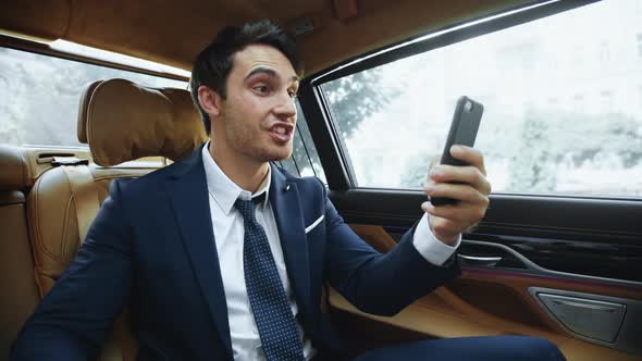 Excited Business Man Having Success at Online Meeting in Business Car