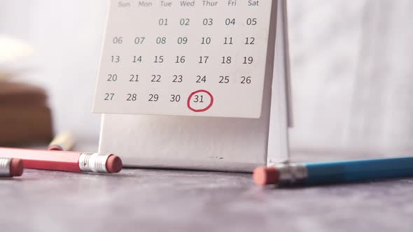 Deadline Concept with Red Mark on Calendar Date with Book and Pencils on Table