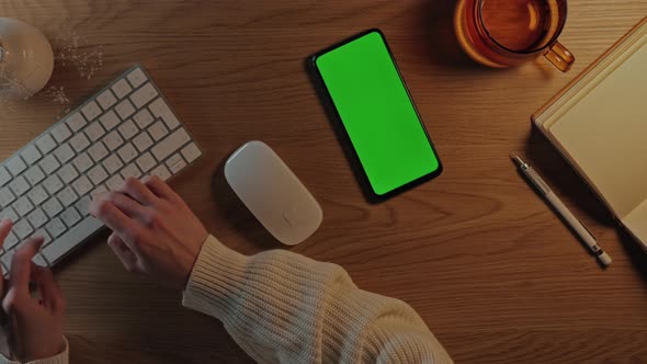 Woman Typing on Keyboard and Using Green Screen Mobile