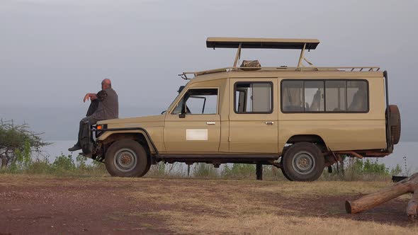 A Male Tourist Watches Africa Landscape by Safari Vehicle