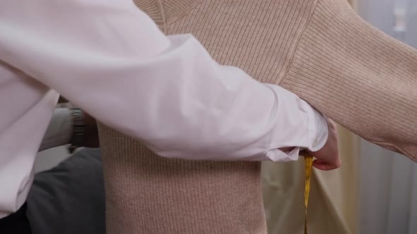 Female Seamstress Measures the Customer with a Measuring Tape