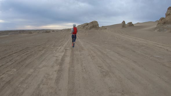 Fitness woman trail runner cross country running  on desert