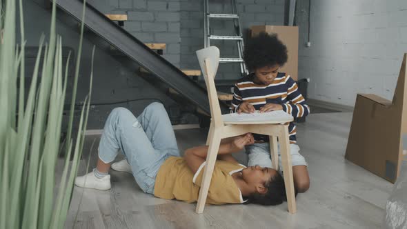 Girl and Boy Assembling Chair Together