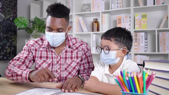 African teacher and student sitting in a room and wearing mask in private class to protect COVID19