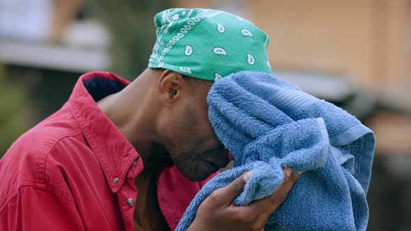 Closeup of Satisfied Tired African American Man Rubbing Wet Face with Cloth in Garden