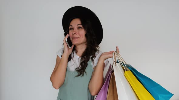 The Girl is Joyful Makes Purchases with Packages and Speaks on the Phone