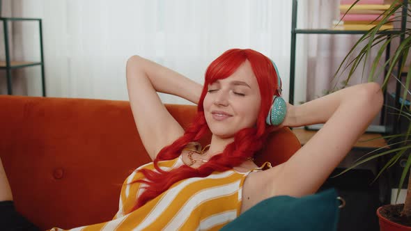 Woman in Wireless Headphones Listening Favorite Disco Music Relaxing Sleeping Resting at Home Couch
