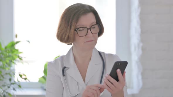 Senior Female Doctor Celebrating on Smartphone