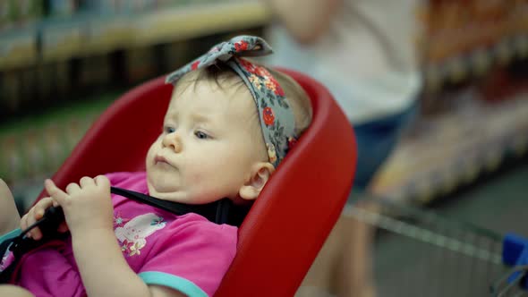 Child Sits in a Specially Equipped Chair 11 in the Supermarket 7