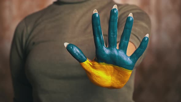 Hand of a Girl With the Flag of Ukraine Asks to Stop the War