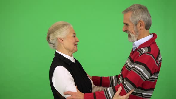 An Elderly Couple Hugs and Talks, Then Smiles at the Camera - Green Screen Studio