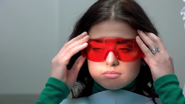 Woman Putting on Safety Glasses.