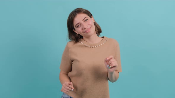 Young Beautiful Woman Dancing and Posing Over Turquoise Background