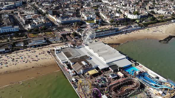 Reverse aerial view of Clacton-on-Sea pier on a sunny afternoon