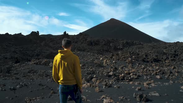 Man Traveler Walks Through the Lava Field Around Chinyero Volcano in the Teide National Park on the