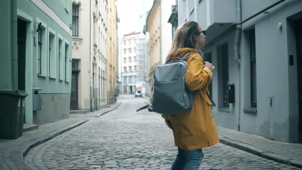 One Tourist Walks in a City, Smiling.