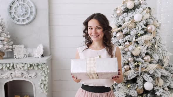 Attractive Brunette with Christmas Gifts on a Background of a Beautiful Interior. Christmas House